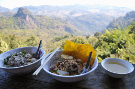 Rice noodle with pork and egg on wooden table, Thailandの写真素材