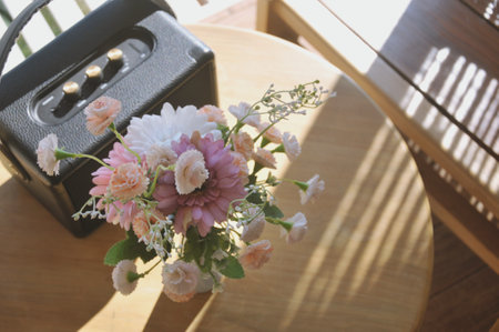 Bouquet of flowers in black plastic box on wooden table.の写真素材