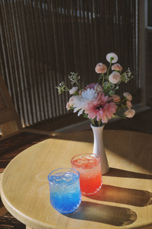 Colorful cocktails on a wooden table in a cafe with flowers.の写真素材