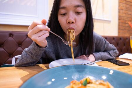 asian women eat Spaghetti Looks deliciousの写真素材