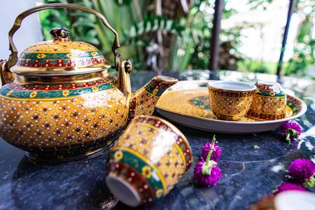 Antique Benjarong porcelain golden tea set on Stone table, ceramics porcelainの写真素材