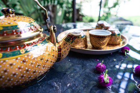 Antique Benjarong porcelain golden tea set on Stone table, ceramics porcelainの写真素材