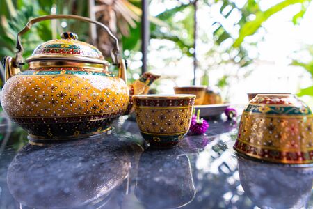 Antique Benjarong porcelain golden tea set on Stone table, ceramics porcelainの写真素材
