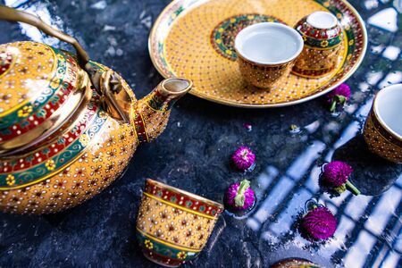 Antique Benjarong porcelain golden tea set on Stone table, ceramics porcelainの写真素材