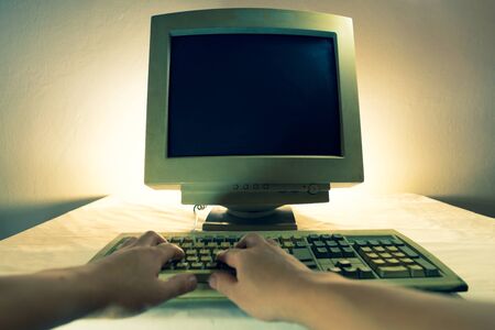 A man using an old personal computer and monitor . Ancient conceptの写真素材