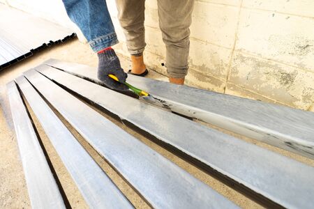 Worker painting steel tube with paintbrushの写真素材