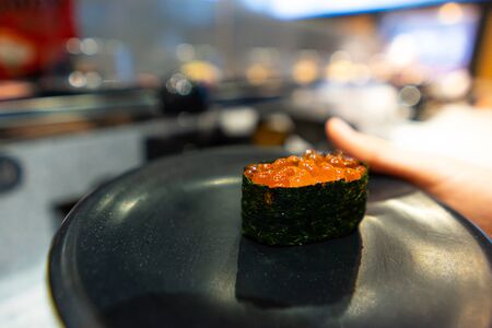 Salmon Roe Sushi on a black dish in a Japanese restaurantの写真素材