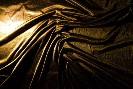 Gold luxury satin fabric texture and shadow for backgroundの写真素材