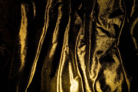 Gold luxury satin fabric texture and shadow for backgroundの写真素材