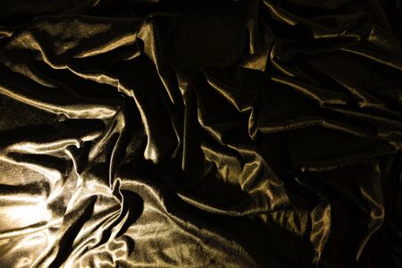 Gold luxury satin fabric texture and shadow for backgroundの写真素材