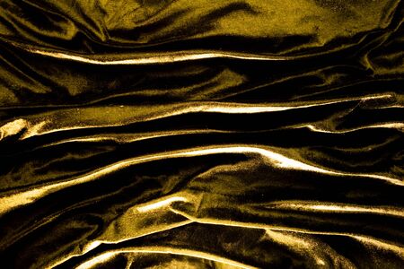 Gold luxury satin fabric texture and shadow for backgroundの写真素材
