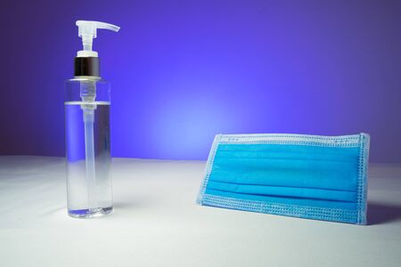 Alcohol gel In the pump bottles Used for sterilize And a mask Used to prevent Covid 19. In the blue backgroundの写真素材