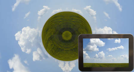 Tab with green farmland and cloudy blue skyの写真素材