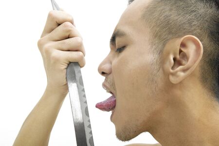 Close-up of young man ready to lick the swordの写真素材