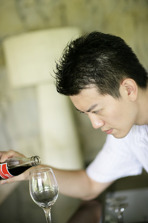 Side view of young man pouringの写真素材