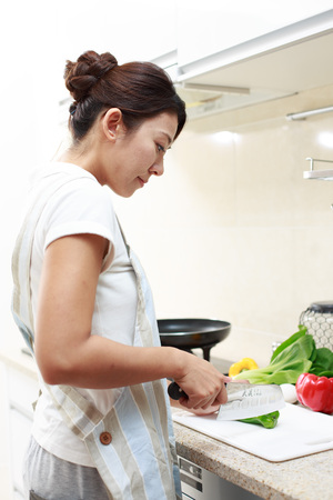 Asian young woman is cutting pepperのeditorial素材