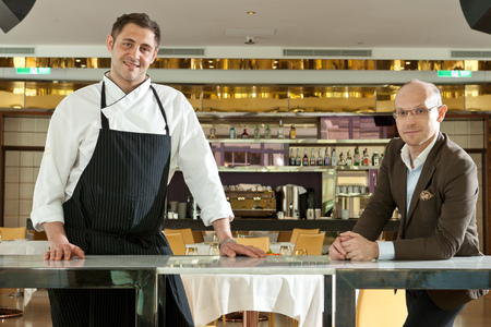 chef and a white man standing in front of the barのeditorial素材