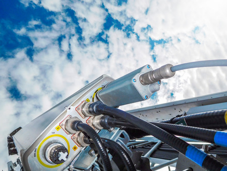 Mobile telephone network base station telecommunication tower with smart cellular antennas radiating and broadcasting strong digital signal waves from view from the topの写真素材