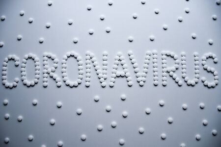 Text phrase Coronavirus sign concept made from white pills on a white backgroundの写真素材