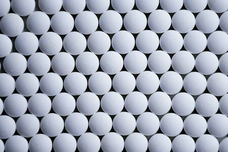 White tablets folded on a pharmaceutical factory production line close up patternの写真素材