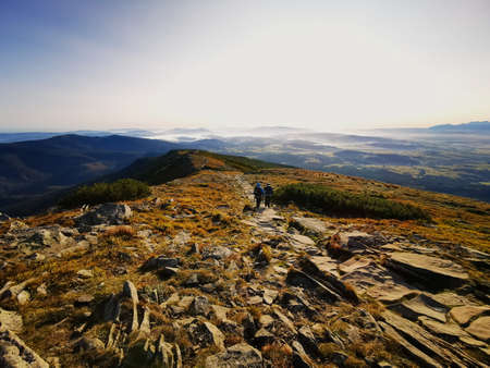 Two people coming down the mountain at sunrise. Babia Gora Poland.の写真素材