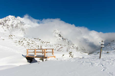 Bridge in the mountains, rolling clouds in the background. Winter in the Valley of the Five Polish Ponds. Winter in the Tatra Mountains, Poland.の写真素材
