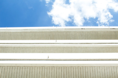 Building with blue sky and white clouds floating in the sky.