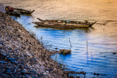 Fishing boats rest along the river park.の写真素材