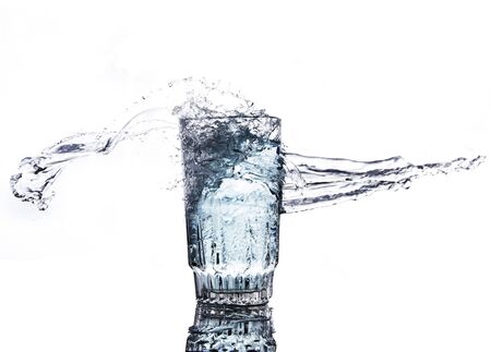 The movement of water in a glass of white backdrop.の写真素材