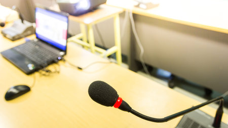 Black conference microphone and computer used for meetings and training for enterprise development.