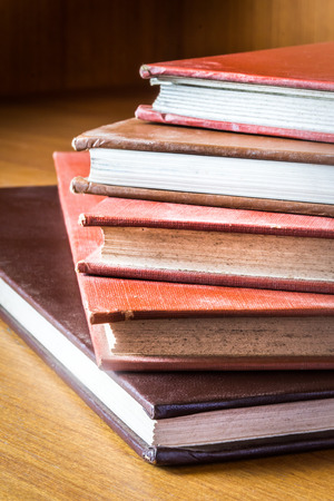Books hardcover color produced by hand in a medical library, arranged on a wooden table.の写真素材