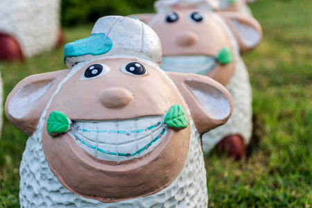 Close Up animal statues smiling on green grass.の写真素材