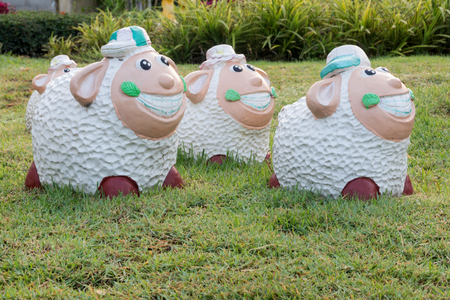 Close Up animal statues smiling on green grass.の写真素材
