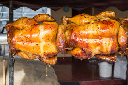 Two chickens were roasted until the yellow spice.の写真素材