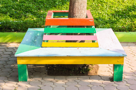 Colorful with a bench around a tree in the garden.の写真素材