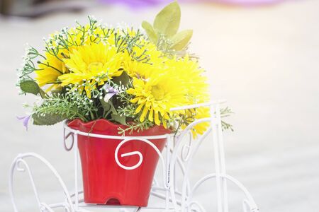 Blurred yellow flowers in a red vase.の写真素材