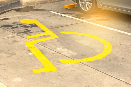 Symbol on a yellow ground parking for people with disabilities.の写真素材