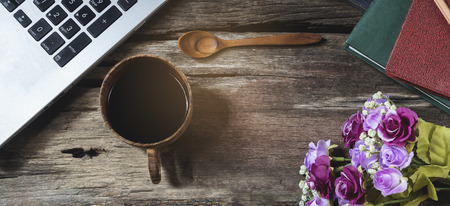 Top view black coffee mug with notebook and flower.の写真素材