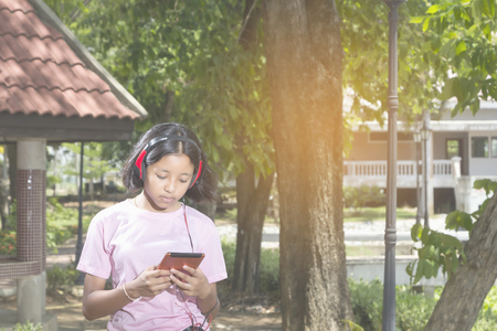 Girl relaxing with music in the park.の写真素材