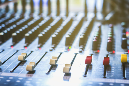Slide the volume control of the audio mixer in a recording studio.の写真素材