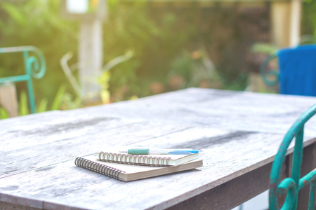 Good morning with a good diary with a pen on an old wooden desk in the garden.の写真素材