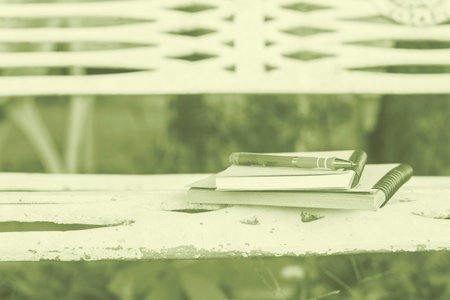 Diary of memories. Notebook and pen on steel benches in the park.の写真素材