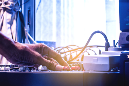 Man's hands control the sound. The microphone and the audio mixer.の写真素材