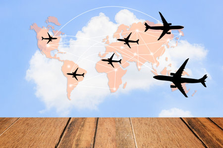 Wood Terrace for workspace and a world map background with blue sky, white clouds, airplane-shaped...