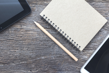 Pencils, notebooks and tablets on old wood, internet and communication conferencesの写真素材