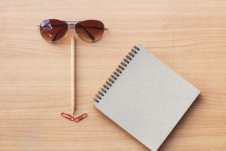 Book, glasses, paper clip on a wooden table. Ideas put a human face wearing glasses.の写真素材