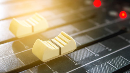 Slides volume of the sound mixer in the studio.