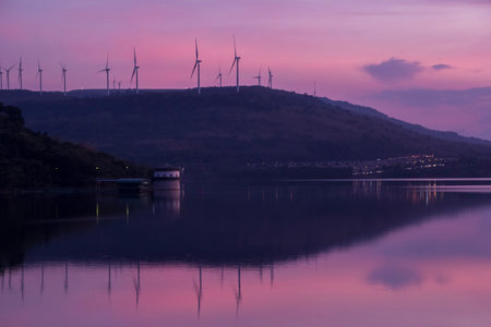 Silhouette of wind turbines generating electricity on the mountain.