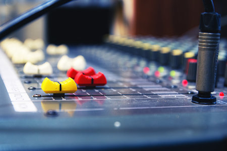 Professional analog audio mixing console with knobs and slides for music and recording equipment,Blurred background and close-up.の写真素材
