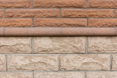 Brick wall with light brown stones.の写真素材